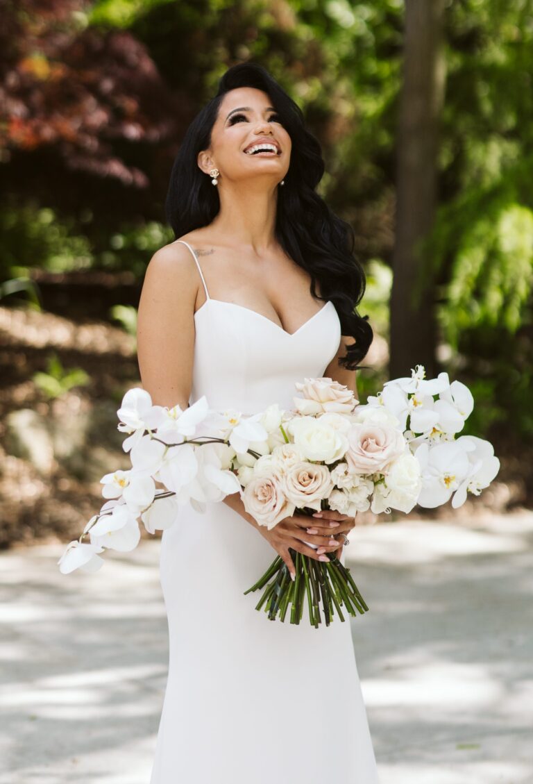 Bride smiles and laughs as she poses for photo.