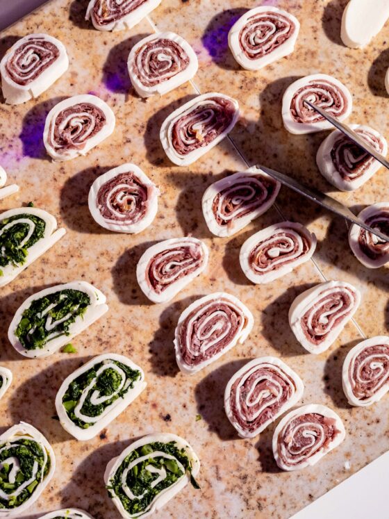 Pinwheel cheese wraps with salami and fresh vegetables.