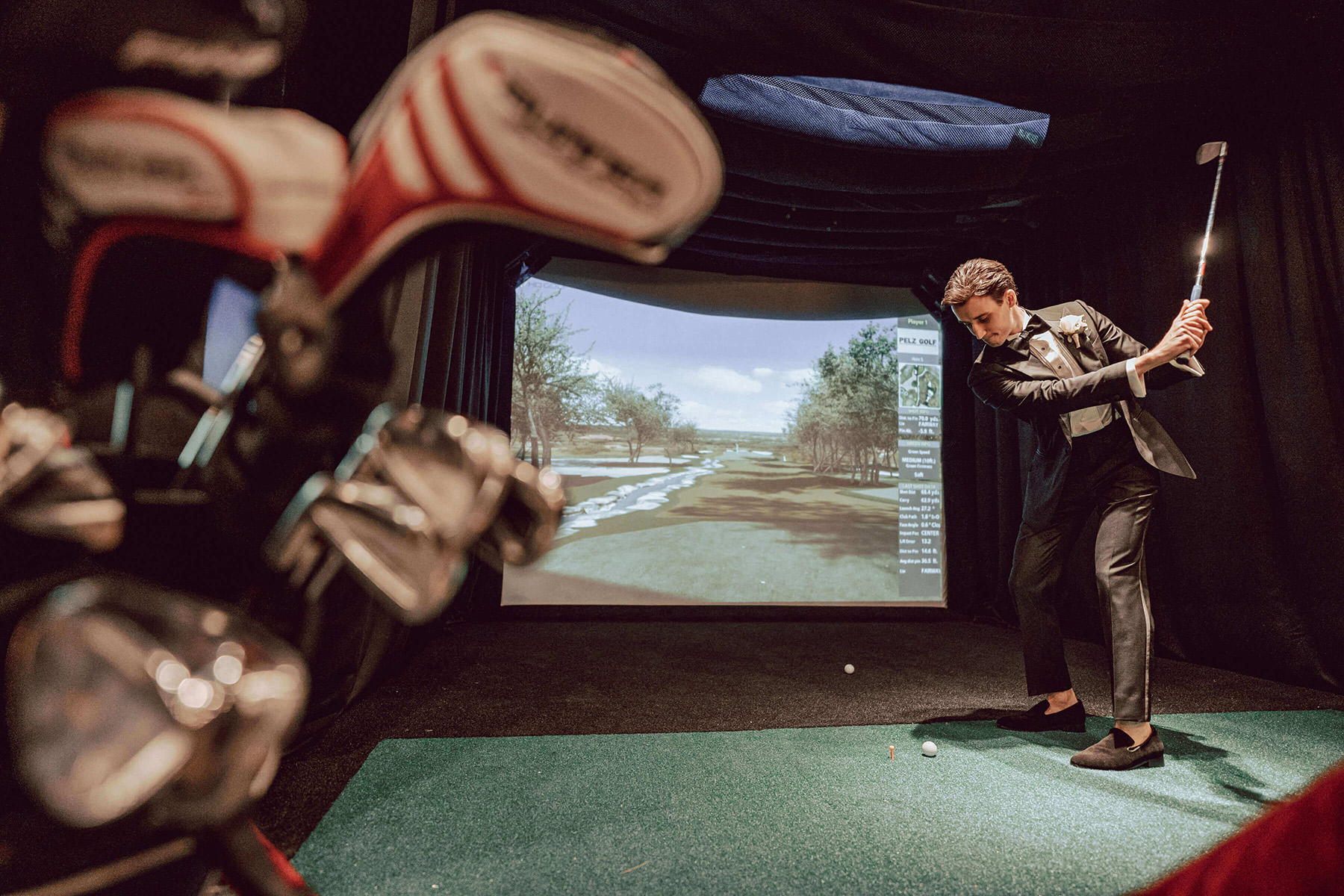 Groom practices his golf swing with the golf simulator in Crystal Plaza's The Vault.