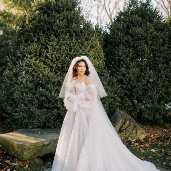 Elegant bride poses for photo in Crystal Plaza's garden.