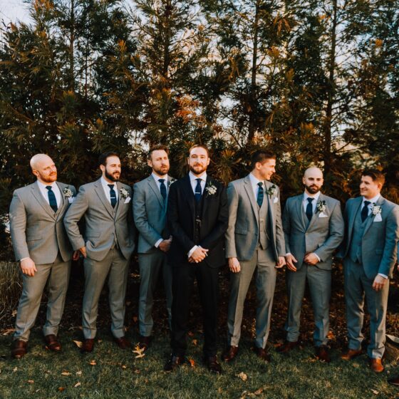 Groom and groomsmen pose for photo in Crystal Plaza's garden.
