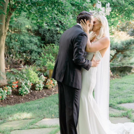 Bride and groom kiss in Crystal Plaza's garden.
