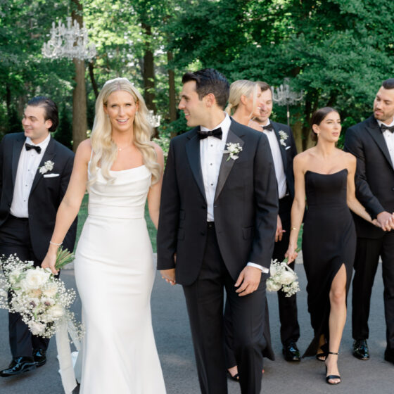 Bride and groom walk with bridal party.