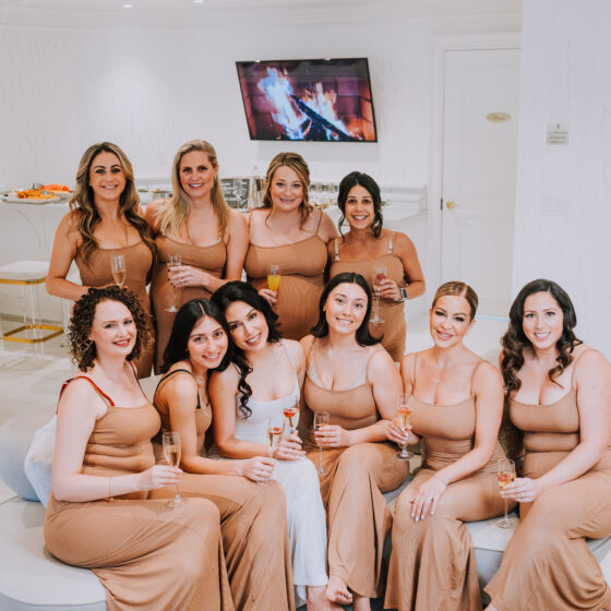 Bride and bridal party pose for photo in Crystal Plaza's Penthouse Suite.