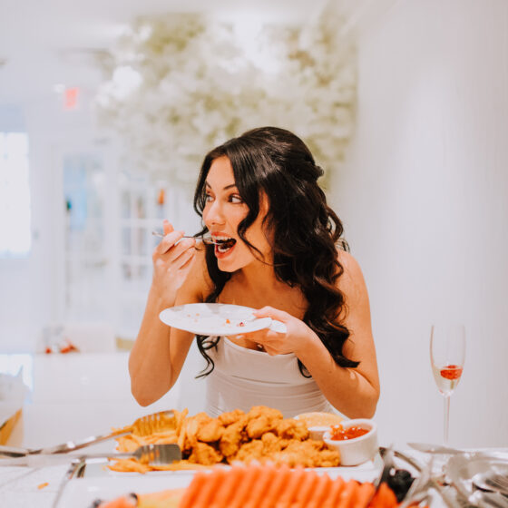 Bride eats food as she gets ready for wedding.