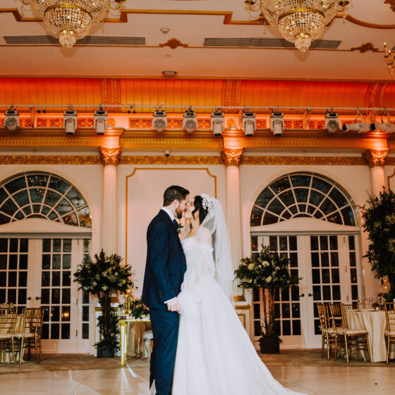 Bride and groom kiss for photo in Crystal Plaza's ballroom.