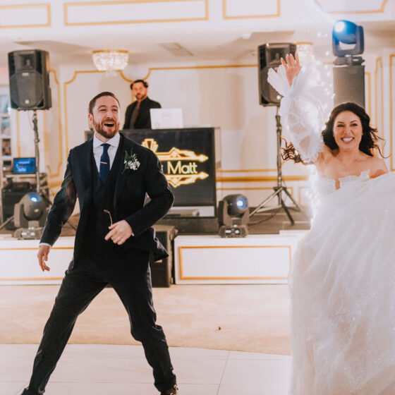 Bride and groom excitedly step onto dance floor.