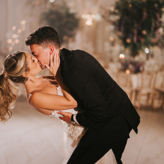 Bride and groom kiss on the dance floor for wedding portrait.