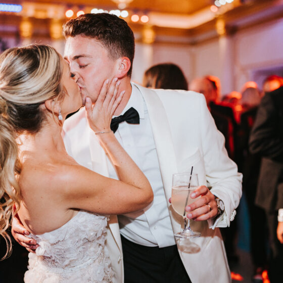 Bride and groom kiss on dance floor.