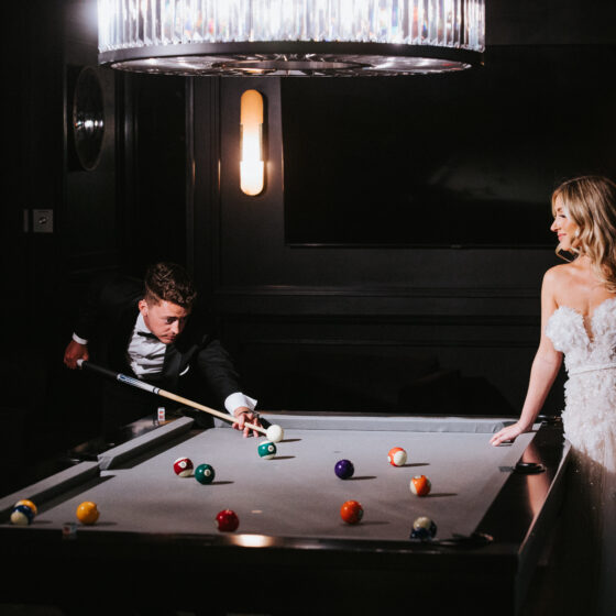 Bride and groom play pool in Crystal Plaza's Vault venue space.