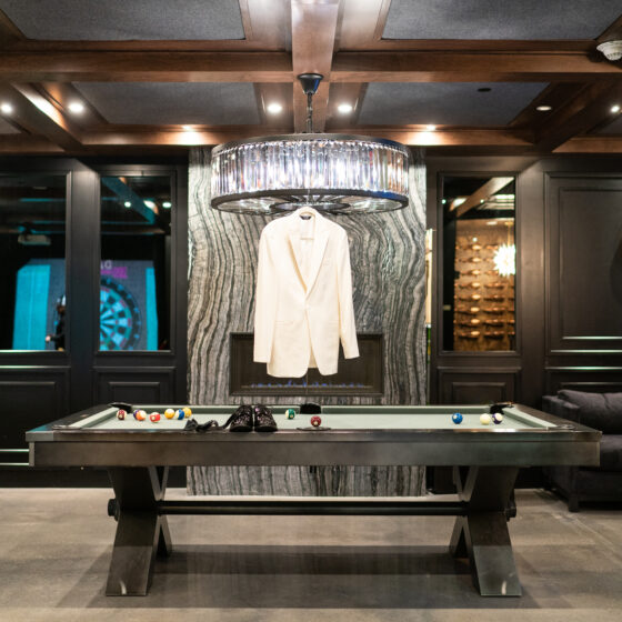 Grooms jacket and dress shoes sit on the pool table in the Vault, a stylish space to get ready in before the wedding.