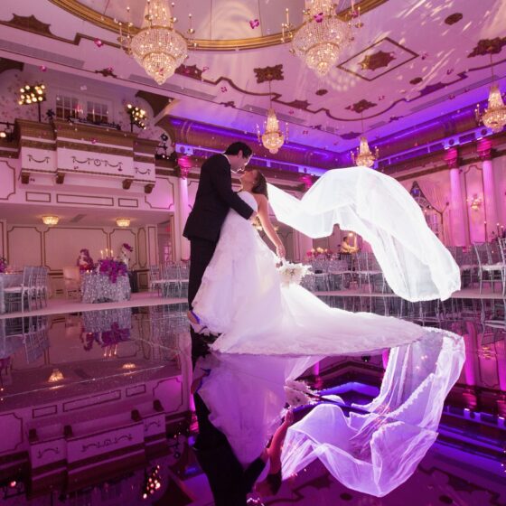 Groom dips bride back on dance floor at Crystal Plaza.