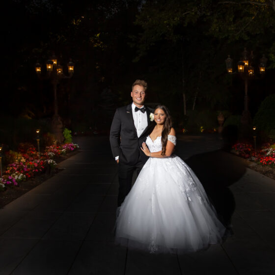 Bride and groom pose for wedding portrait at night in the garden of Crystal Plaza.