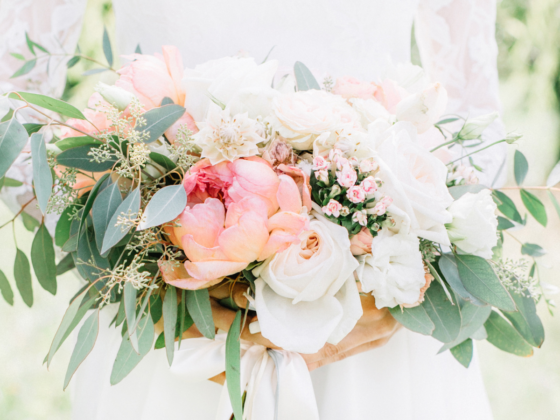 Bridal bouquet filled with pink peonies, white roses, and greenery.