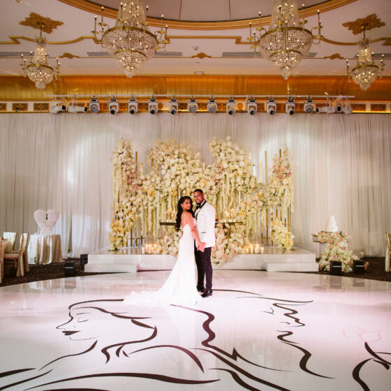 Bride and groom hold hands in Crystal Plaza's grand ballroom.