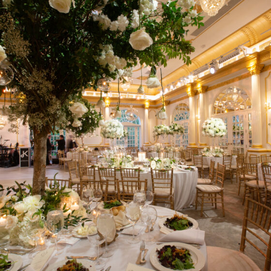 Romantic wedding reception decor filled with white rose tree centerpieces in Crystal Plaza's grand ballroom.