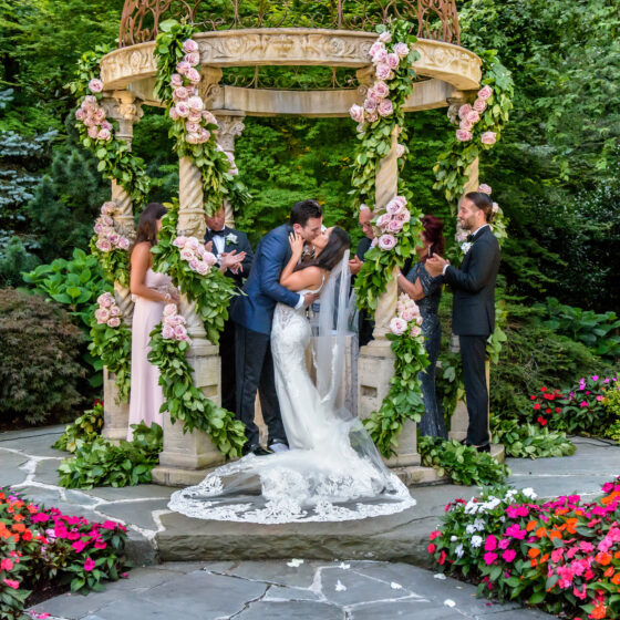 Bride and groom kiss as a just married couple in Crystal Plaza's gardens.