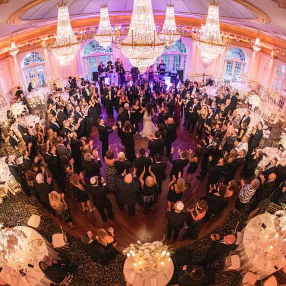 Lively crowd dances during wedding reception in Crystal Plaza's grand ballroom.