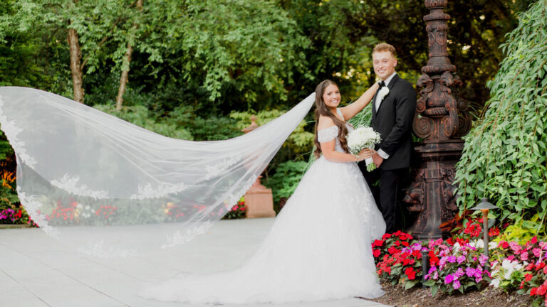 Bride and groom pose for photo in Crystal Plaza's garden.