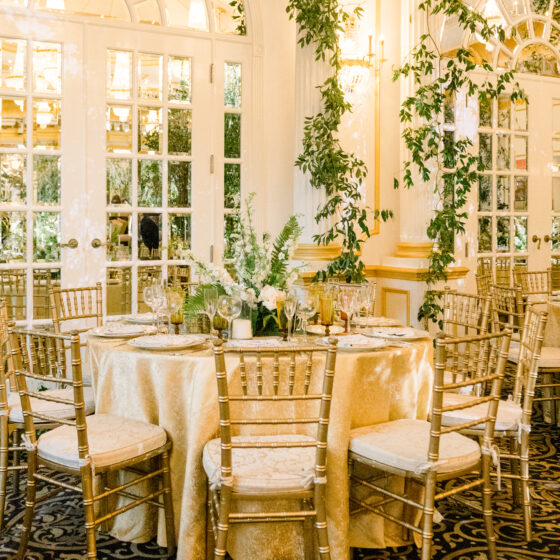 Lush greenery and gold wedding table decor.