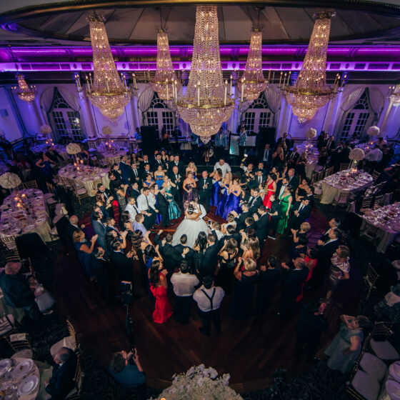 Bride and groom first dance surrounded by guests in Crystal Plaza's grand ballroom.
