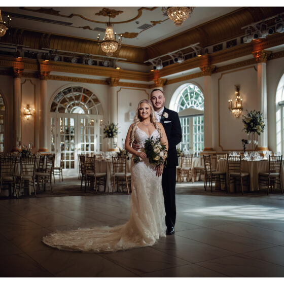 Bride and groom pose for wedding portrait in Crystal Plaza's grand ballroom.