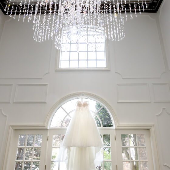 Bridal gown hanging on windows.