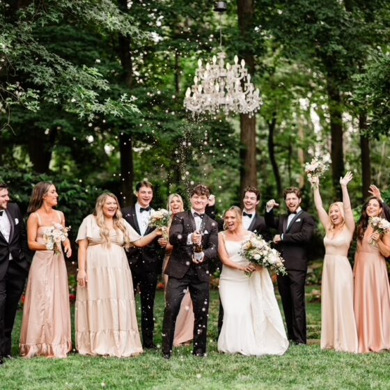 Bride, groom, and bridal party celebrate with champagne in Crystal Plaza's garden.