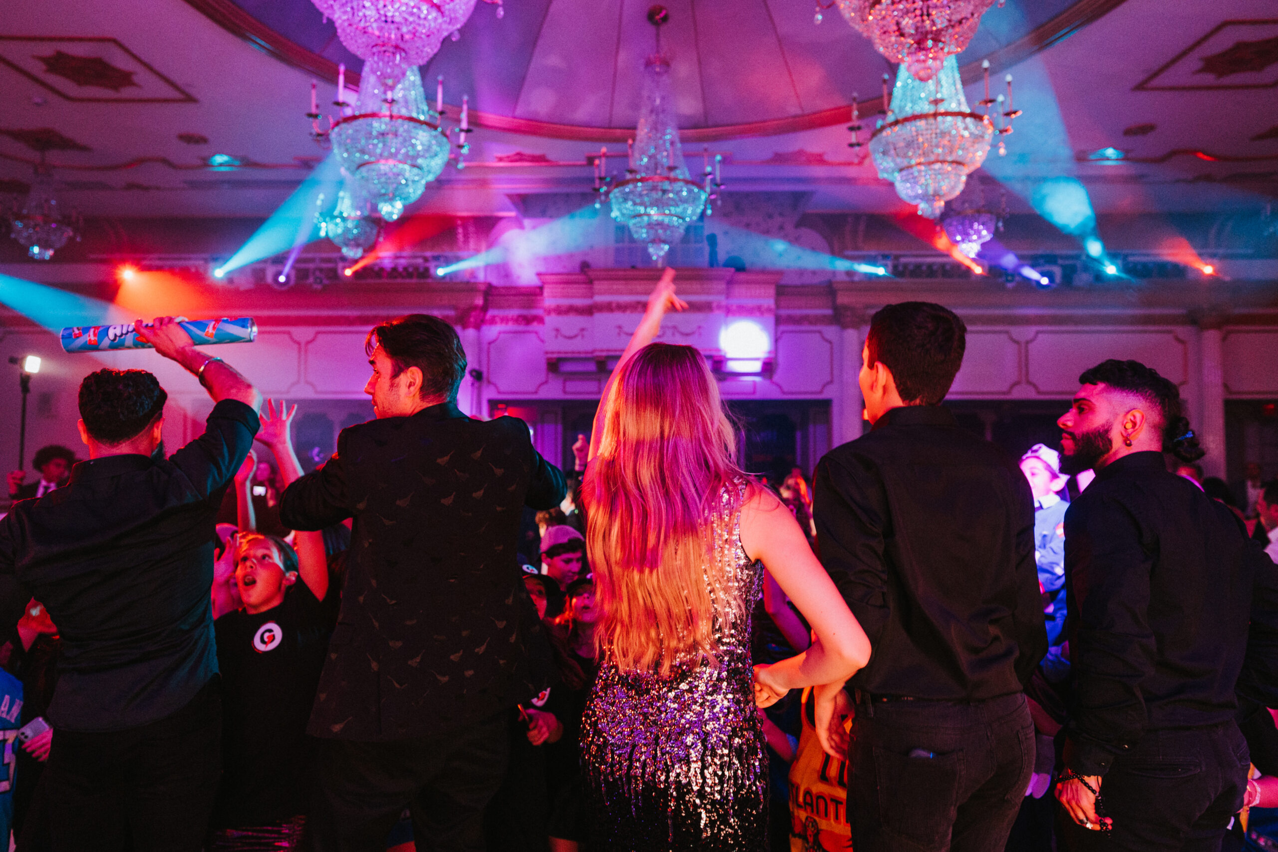 Guests stand on stage facing crowd and dance in Crystal Plaza's Grand Ballroom.